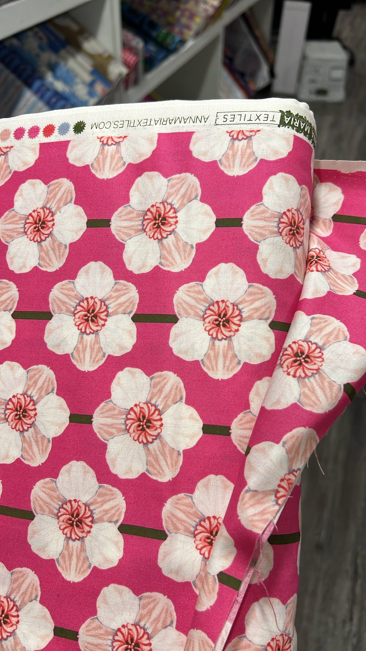 Daffodil in Bubblegum fabric by Anna Maria for Northcott, folded to show the floral print texture on a bright pink ground