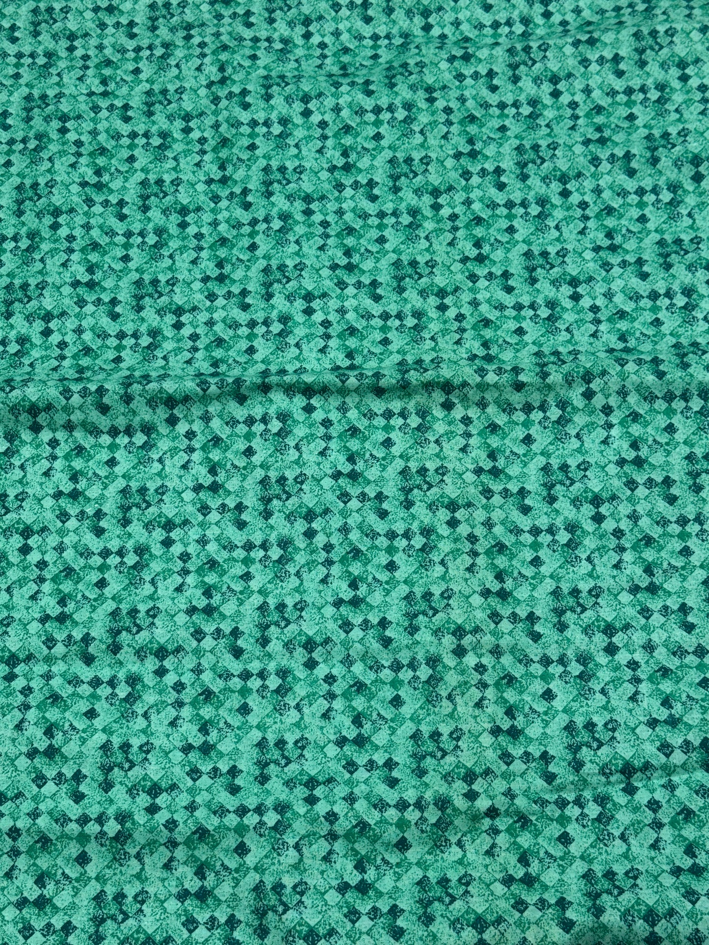 Greenish blue fabric with black and greenish squares