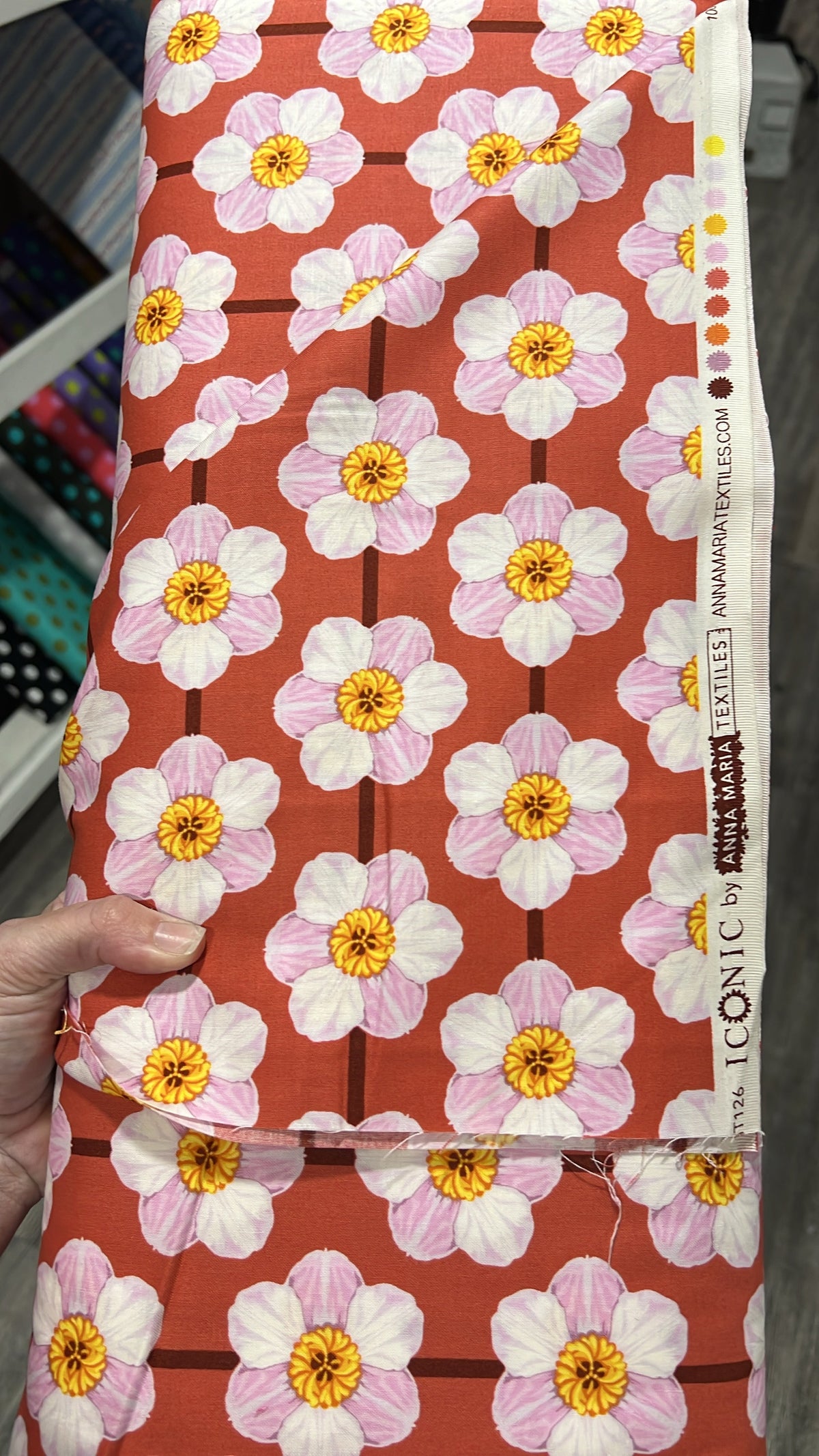 Daffodil in Desert fabric by Anna Maria for Northcott, folded to show the floral print texture on a rust ground
