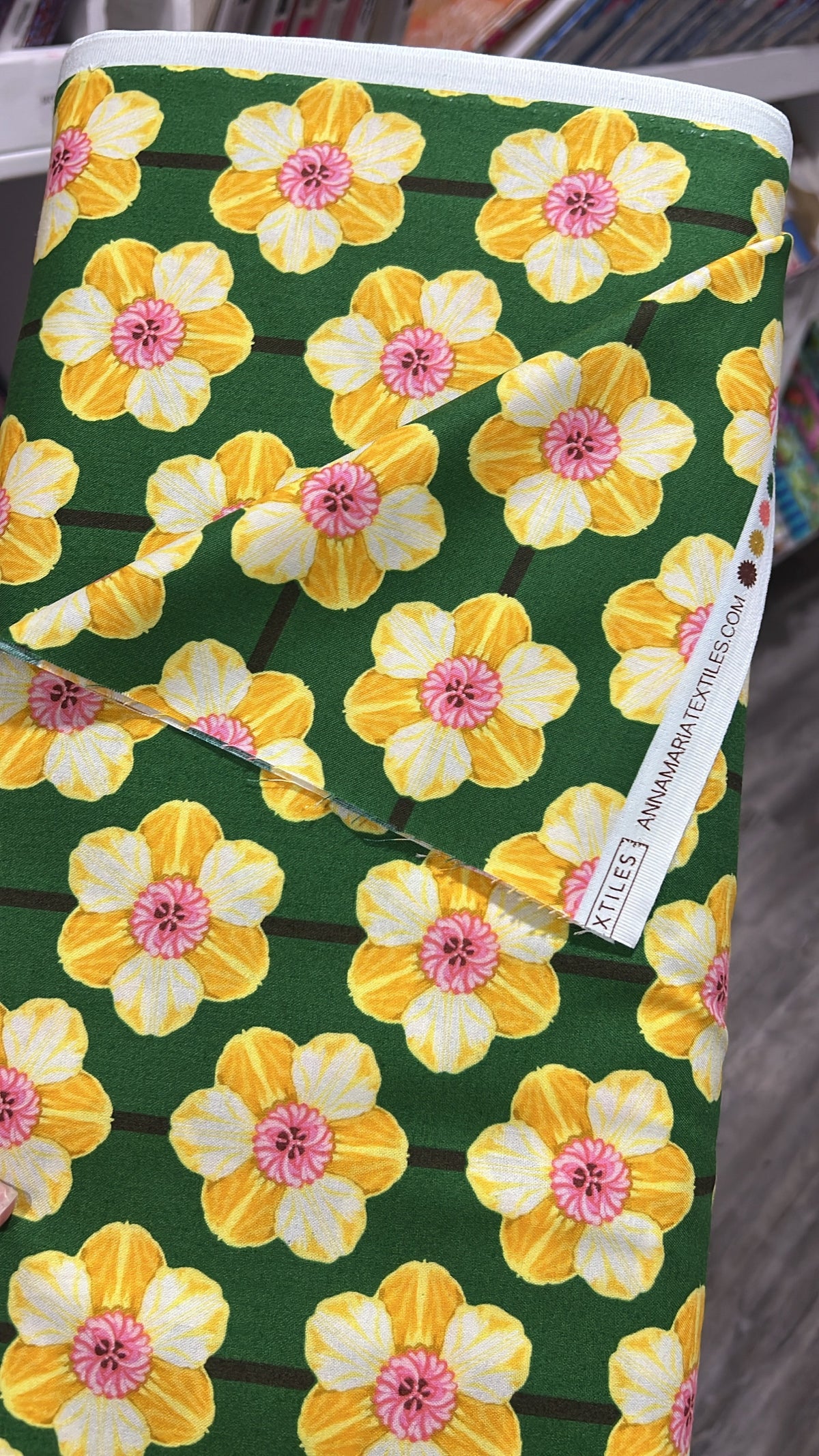 Iconic Verdant Daffodil fabric by Anna Maria for Northcott, folded to show the daffodil floral print texture on a green ground